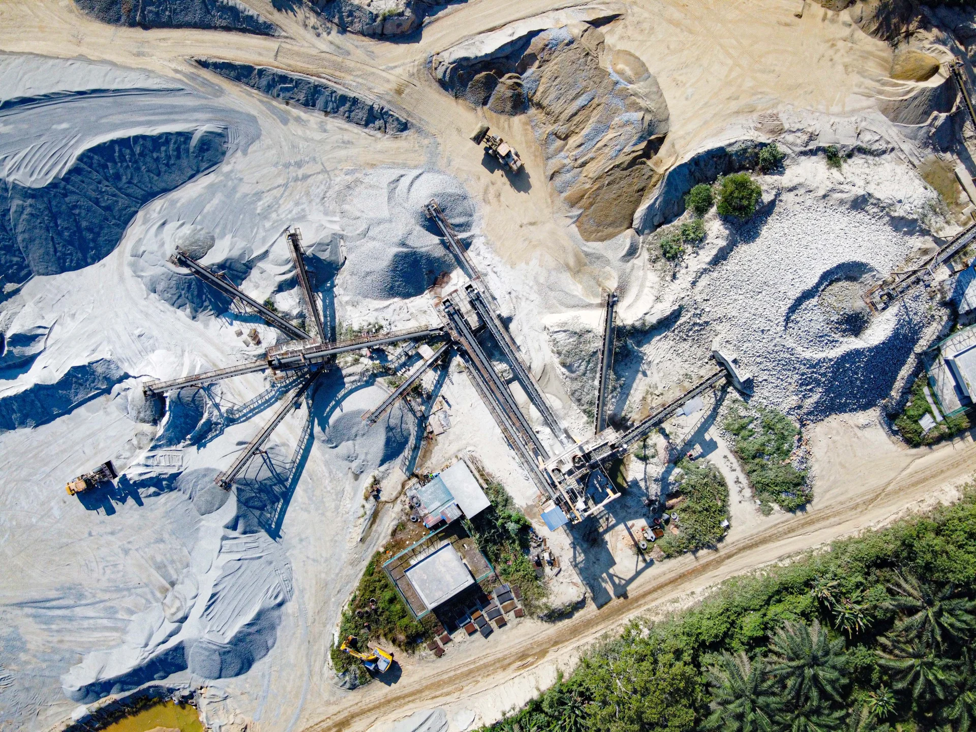 Aerial view of quarry aggregate stockpiles, conveyors, and machinery